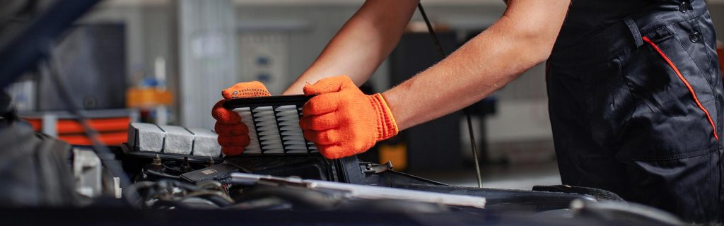 Mechanic replacing a car air filter.