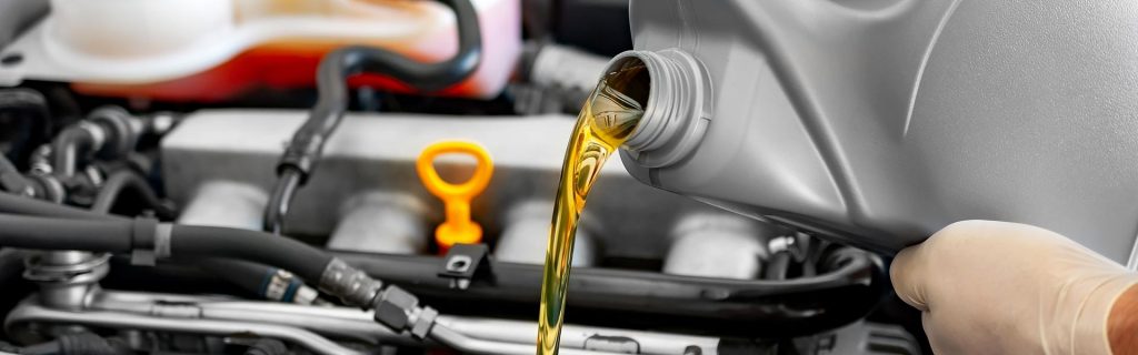Fresh engine oil being poured into a car engine